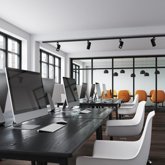 Office and Retail Services Modern office interior with computers, white chairs, and orange seating in the background.